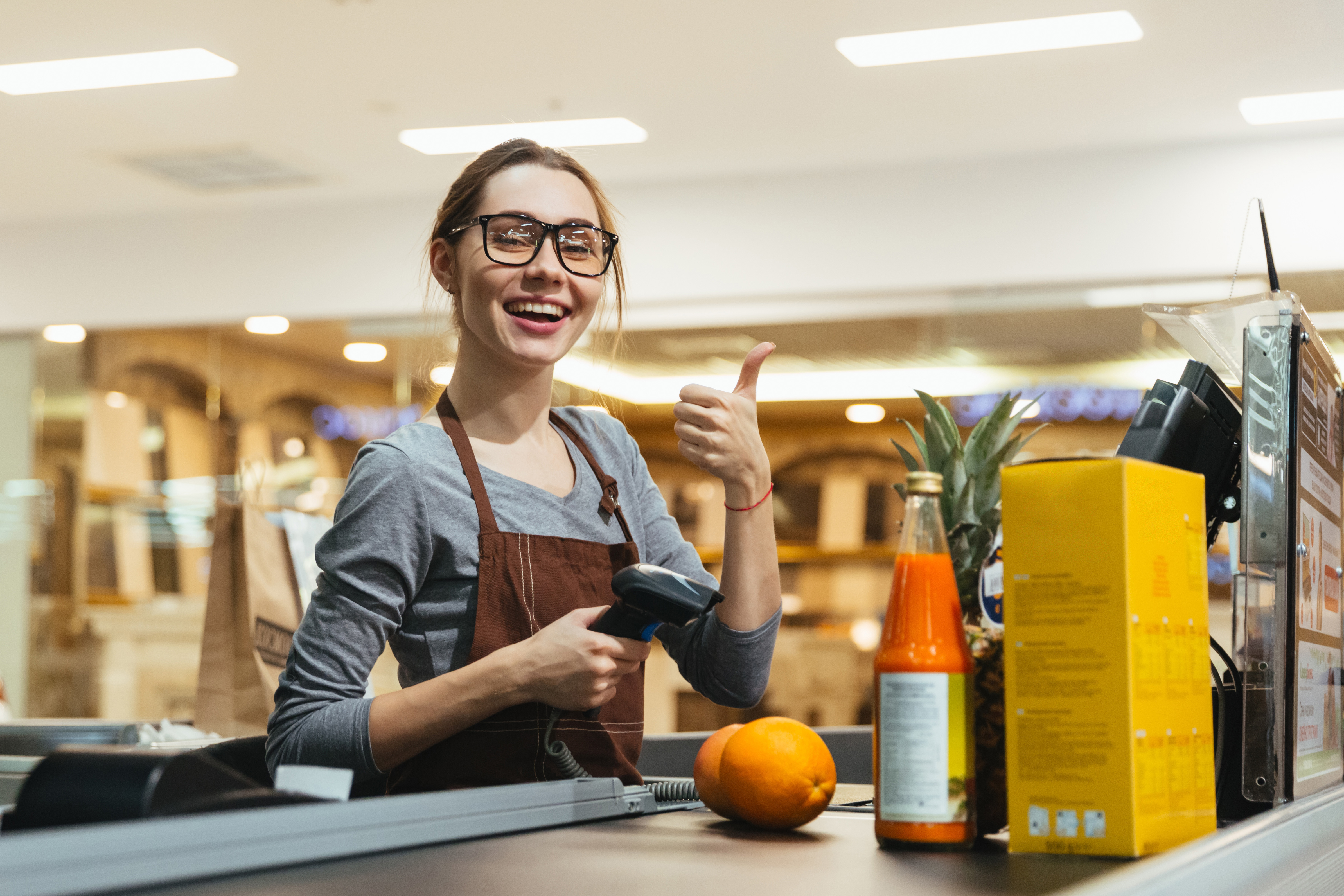 A retail apprentice at a checkout counter